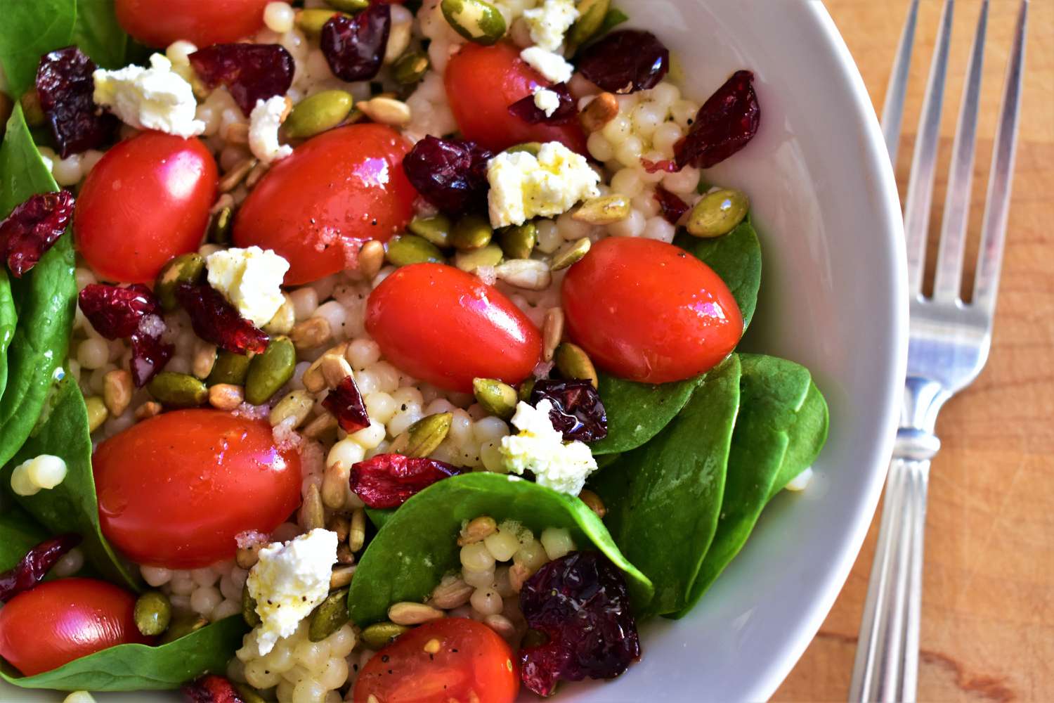 Salad couscous với cải xoăn, cà chua, quả nam việt quất và feta